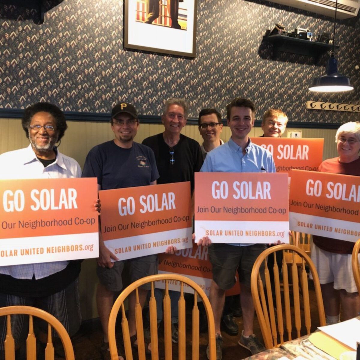 Group holding "Go solar" signs.