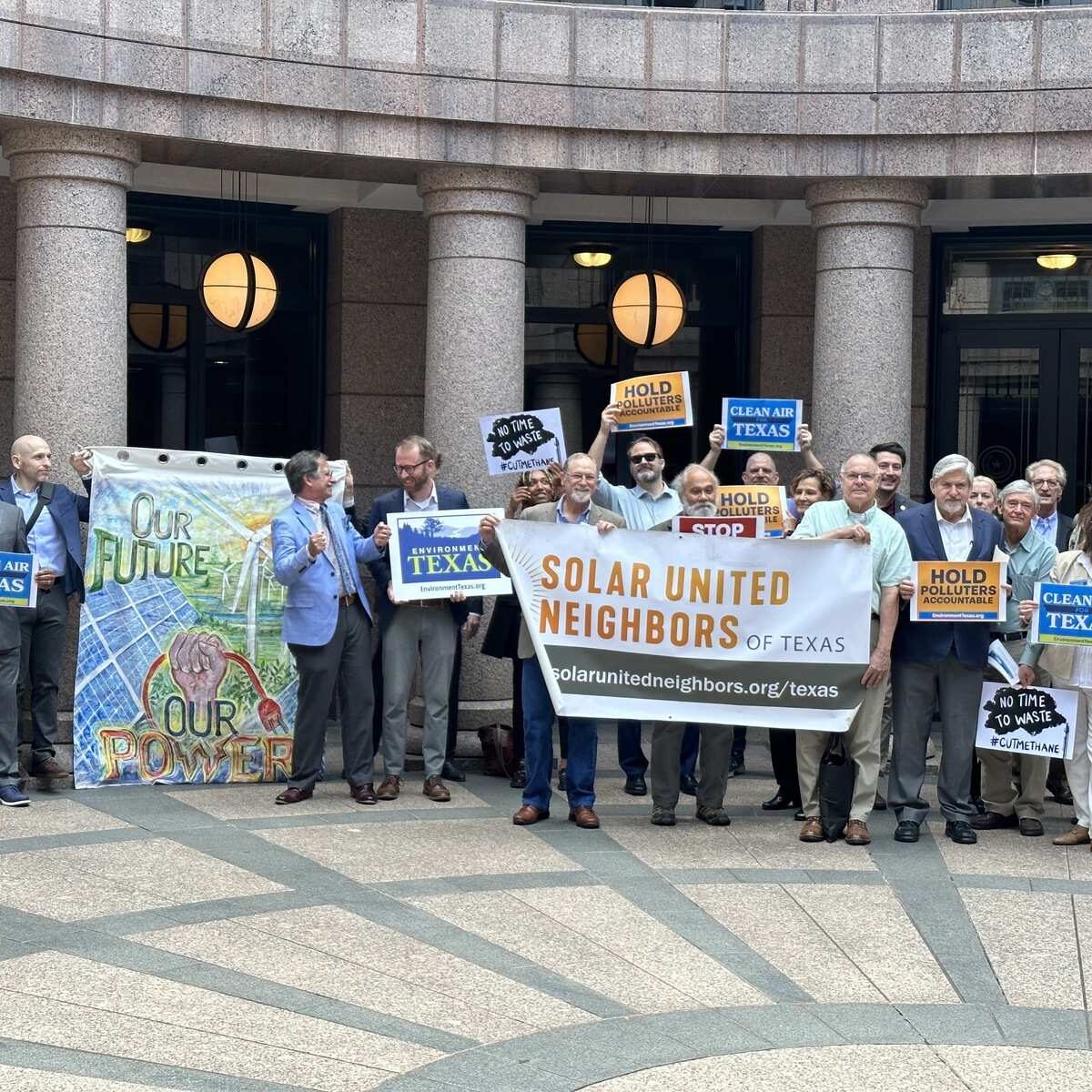 Group of people holding signs supporting clean air in Texas.