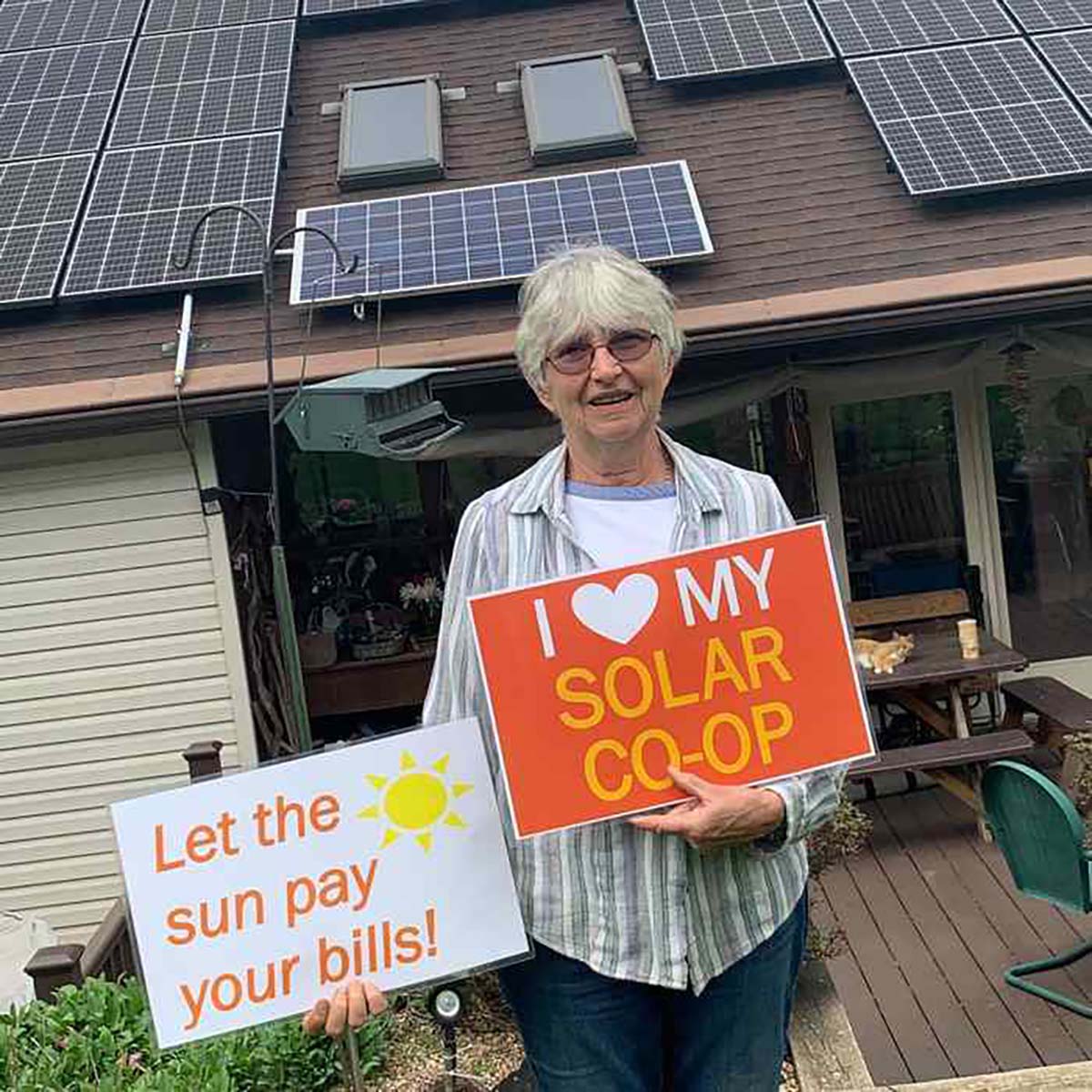 Woman holding sign that says "I love my solar co-op."