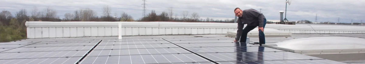 Man crouching down next to solar array