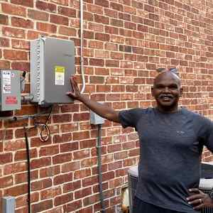 Man standing next to electricity meter.