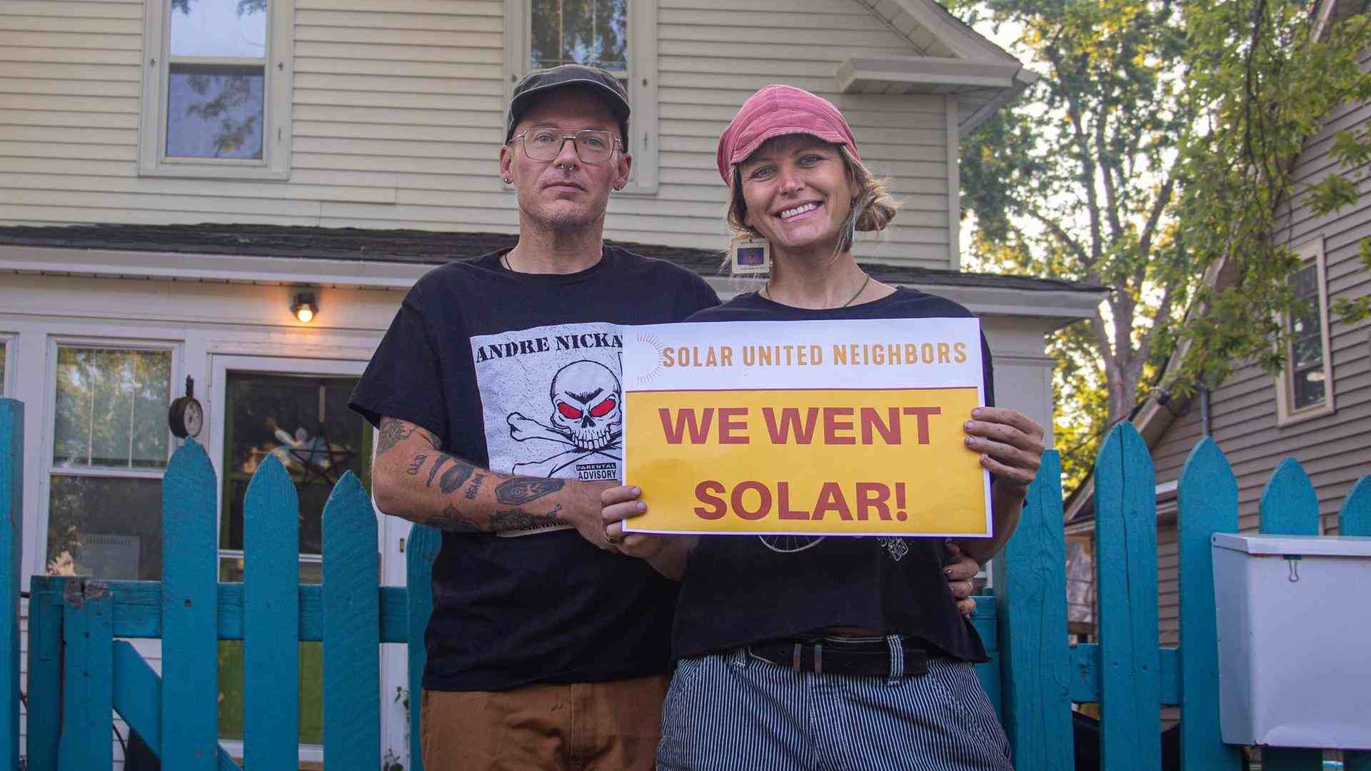 Man and woman hold sign that reads "We went solar"