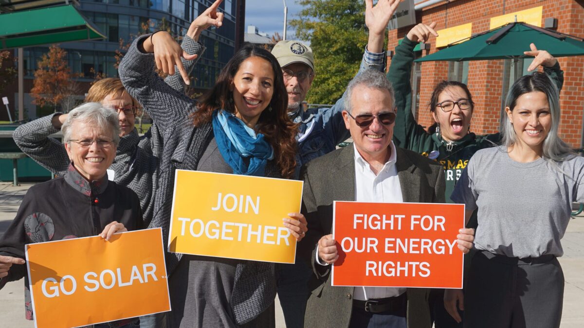 7 people with signs reading go solar, join together and fight for your energy rights