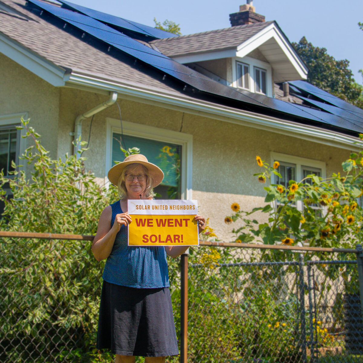 A Minnesota solar co-op participant, stands in front of her solar array.