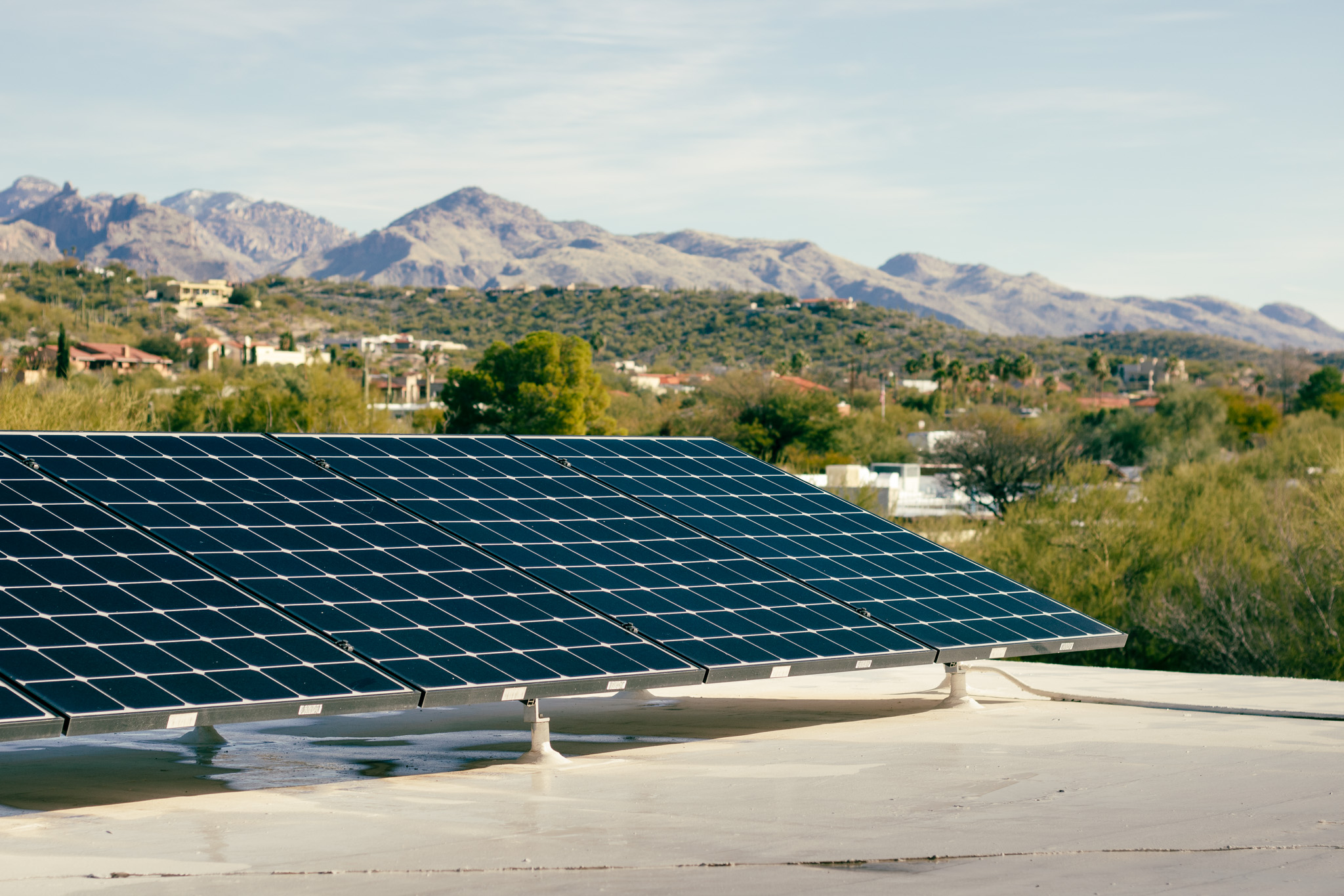 Rooftop solar panels with mountains and trees in the background