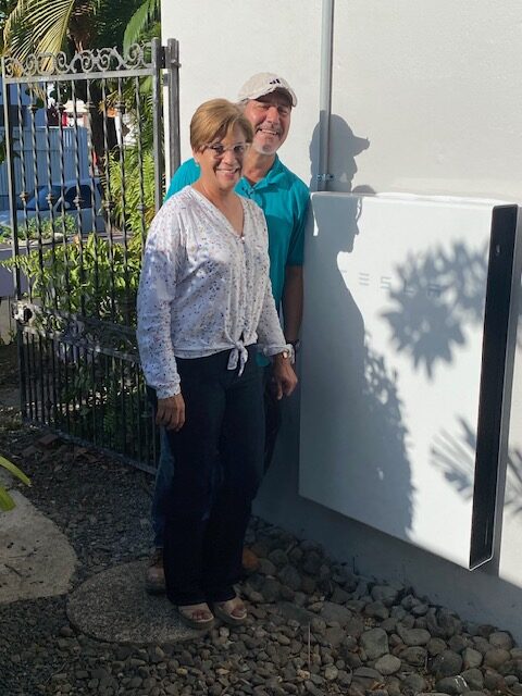 A couple smiling with their solar storage battery.