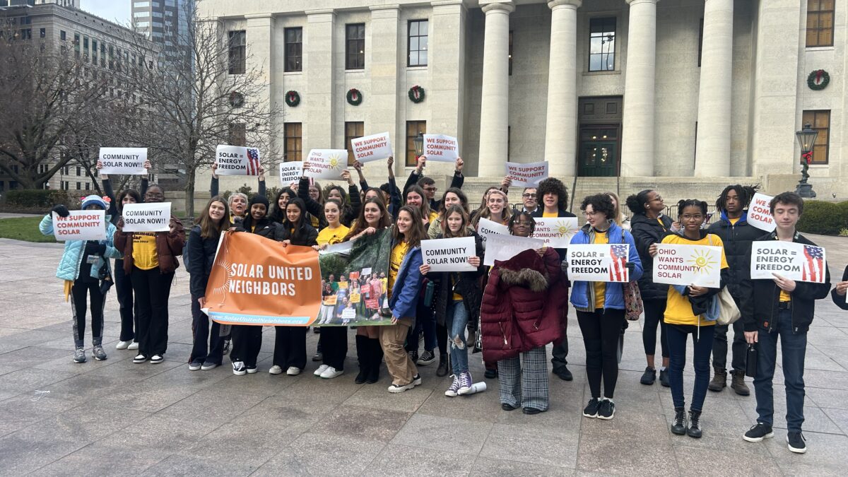 30 people holding signs in support of community solar in Ohio in front of Ohio legislature