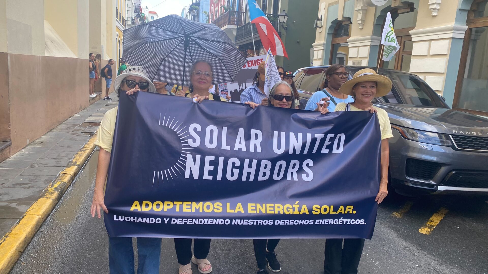 A group holding a Solar United Neighbors banner in Puerto Rico to advocate for clean energy